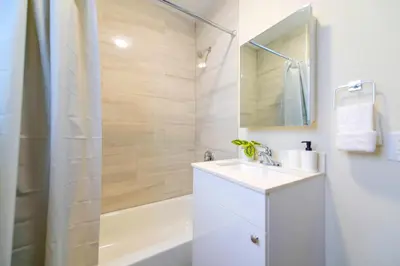 a white bathroom with a sink and a shower at Modern Apartment in Prime Miami Location in Miami
