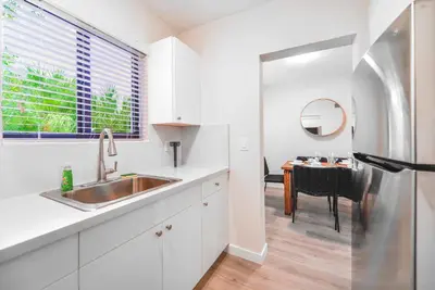 a kitchen with a stainless steel refrigerator and a table at Modern Apartment in Prime Miami Location in Miami