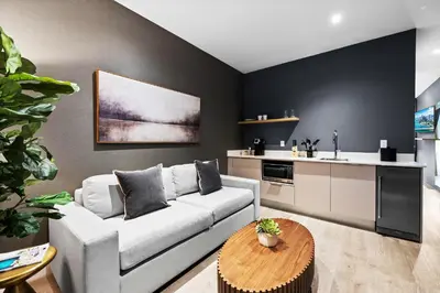 a living room with a white couch and a kitchen at Brickell Condos by Vibras Concierge in Miami