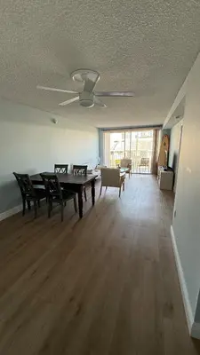 a living room with a ping pong table and chairs at Canal-front two-bedroom condo near Sunny Isles in North Miami Beach