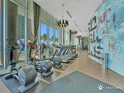 a gym with treadmills and ellipticals in a building at Cozy Apartment -Balcony & Beachfront Resort in Hollywood