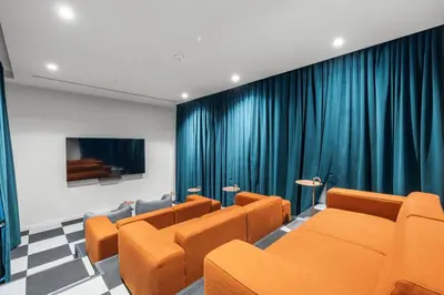 a waiting room with orange chairs and blue curtains at Stylish Condo at The Crosby in Miami