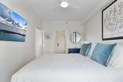a bedroom with a large white bed with blue pillows at Cozy Miami Beach Apartment walking distance to Beach and Ocean in Miami Beach