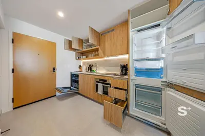 a kitchen with wooden cabinets and an empty refrigerator at Modern and Cozy 1BD Apt with Gym & Pool in Miami