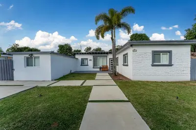 a house with a palm tree in the yard at Cozy house with a pool in Miami in Miami