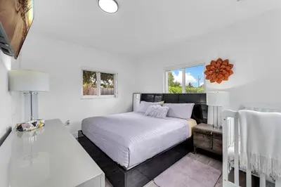 a white bedroom with a bed and a window at Cozy house with a pool in Miami in Miami