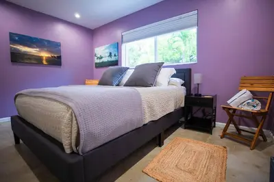 a purple bedroom with a bed and a window at Las Tortugas Modern Oasis Getaway Many Amenities in Fort Lauderdale