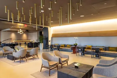 a lobby with chairs and tables and a chandelier at 2105 Modern studio with Balcony a Pool and a 24 hour Gym in Downtown Miami in Miami