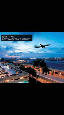 an airplane is flying low over an airport at Florida Cozy Home!!! in Hallandale Beach