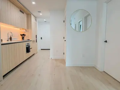 a hallway with a kitchen and a mirror on the wall at City Skyline Views & Rooftop Pool at District 225 in Miami