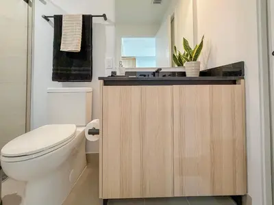 a bathroom with a toilet and a sink at City Skyline Views & Rooftop Pool at District 225 in Miami