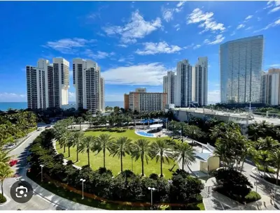 a park with palm trees in front of a city at Beautiful Apartment in Sunny Isles Beach in Sunny Isles Beach