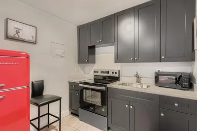 a kitchen with black cabinets and a red refrigerator at Lauderdale Breeze Villas in Fort Lauderdale
