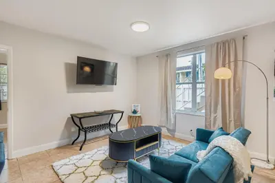 a living room with a blue couch and a tv at Lauderdale Breeze Villas in Fort Lauderdale