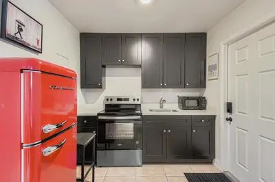 a kitchen with black cabinets and a red refrigerator at Lauderdale Breeze Villas in Fort Lauderdale