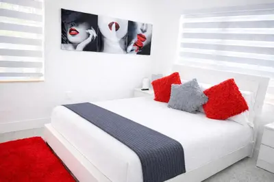 a bedroom with a white bed with red pillows at Villa Clara EPIC-Little Havana in Miami