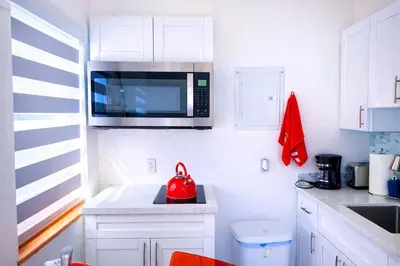 a kitchen with a microwave and a red tea kettle at Villa Clara EPIC-Little Havana in Miami
