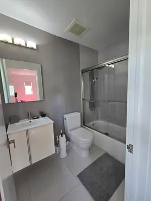a bathroom with a toilet and a sink and a shower at West Ave in Miami Beach