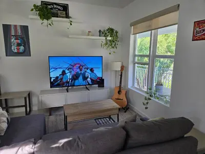 a living room with a couch and a flat screen tv at West Ave in Miami Beach
