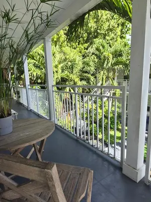 a porch with a wooden table and a fence at West Ave in Miami Beach
