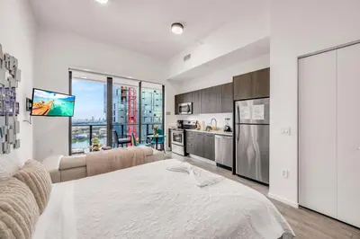a living room with a large bed and a kitchen at Bay Views Studio in Miami