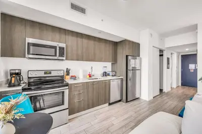 a kitchen with stainless steel appliances and wooden cabinets at Sublime Views Studio in Miami