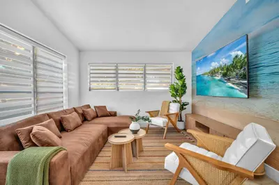 a living room with a brown couch and a painting at Palm Fiction - Pool and Hard Rock Casino in Hollywood