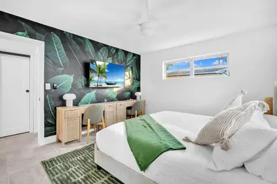 a bedroom with a bed and a desk with a television at Palm Fiction - Pool and Hard Rock Casino in Hollywood