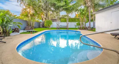 a swimming pool in a yard with trees at Palm Fiction - Pool and Hard Rock Casino in Hollywood