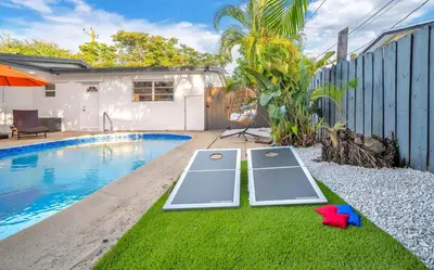a swimming pool with two ping pong tables next to a house at Palm Fiction - Pool and Hard Rock Casino in Hollywood