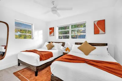 two beds in a room with white walls and windows at Palm Fiction - Pool and Hard Rock Casino in Hollywood