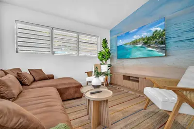 a living room with a couch and a large screen tv at Palm Fiction - Pool and Hard Rock Casino in Hollywood