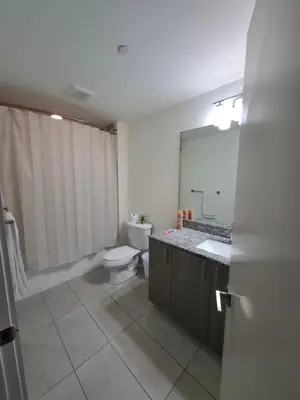 a bathroom with a toilet and a sink and a mirror at Amazing view day & night doral in Miami