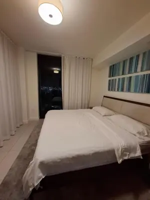 a bedroom with a large white bed with a window at Amazing view day & night doral in Miami