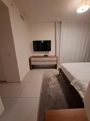 a bedroom with a bed and a flat screen tv at Amazing view day & night doral in Miami