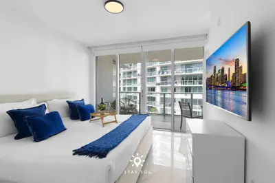 a bedroom with a large bed and a large window at Luxury Coastal Escape Balcony views - Free Parking in Miami Beach