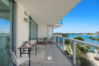 a balcony with a table and chairs and a view of the water at Luxury Coastal Escape Balcony views - Free Parking in Miami Beach