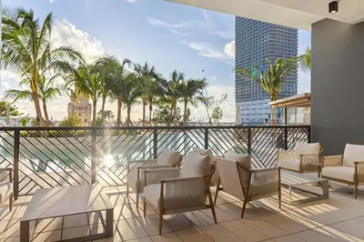 a balcony with chairs and tables and palm trees at 4612 High-Floor Studio w Skyline View and a 24-hour Gym in Downtown Miami in Miami