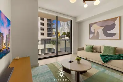 a living room with a couch and a large window at High Rise Haven with Pool Cowork & Spa in Miami in Miami