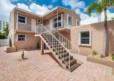a house with a staircase in front of it at Lauderdale Breeze Villas - Luxury 3 BR Coastal Retreat in Fort Lauderdale