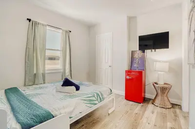 a bedroom with a bed and a red dresser at Lauderdale Breeze Villas - Luxury 3 BR Coastal Retreat in Fort Lauderdale