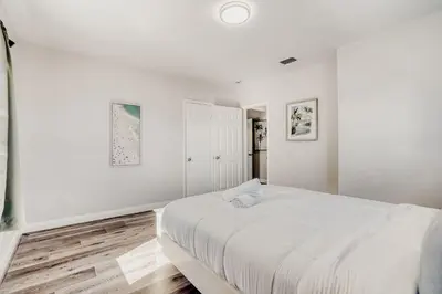 a white bedroom with a large white bed at Lauderdale Breeze Villas - Luxury 3 BR Coastal Retreat in Fort Lauderdale
