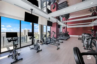 a gym with treadmills and ellipticals in a room with windows at Luxurious & Stylish 2BD Apt in Miami Gym & Pool in Miami