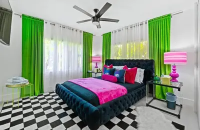 a bedroom with a black bed with green curtains at Delano in Fort Lauderdale