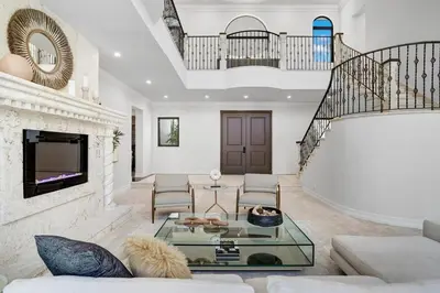 a living room with a glass table and a staircase at WATERFRONT MANSION Las Olas in Fort Lauderdale