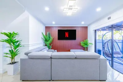 a living room with a n on the wall at West Kendall Retreat Everglades Miccosukee in Hammocks