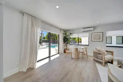 a white living room with a table and a couch at Waterfront Unit #2 20 Min Walk to Beach and Shops in Fort Lauderdale