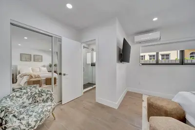a white bedroom with a bed and a sliding glass door at Waterfront Unit #3 20 Min Walk to Beach and Shops in Fort Lauderdale