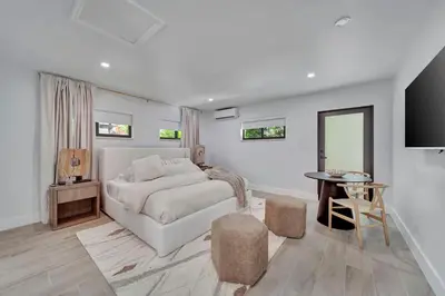 a white bedroom with a bed and a table at Waterfront Unit #5 20 Min Walk to Beach and Shops in Fort Lauderdale
