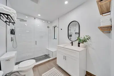 a white bathroom with a toilet and a mirror at Waterfront Unit #5 20 Min Walk to Beach and Shops in Fort Lauderdale